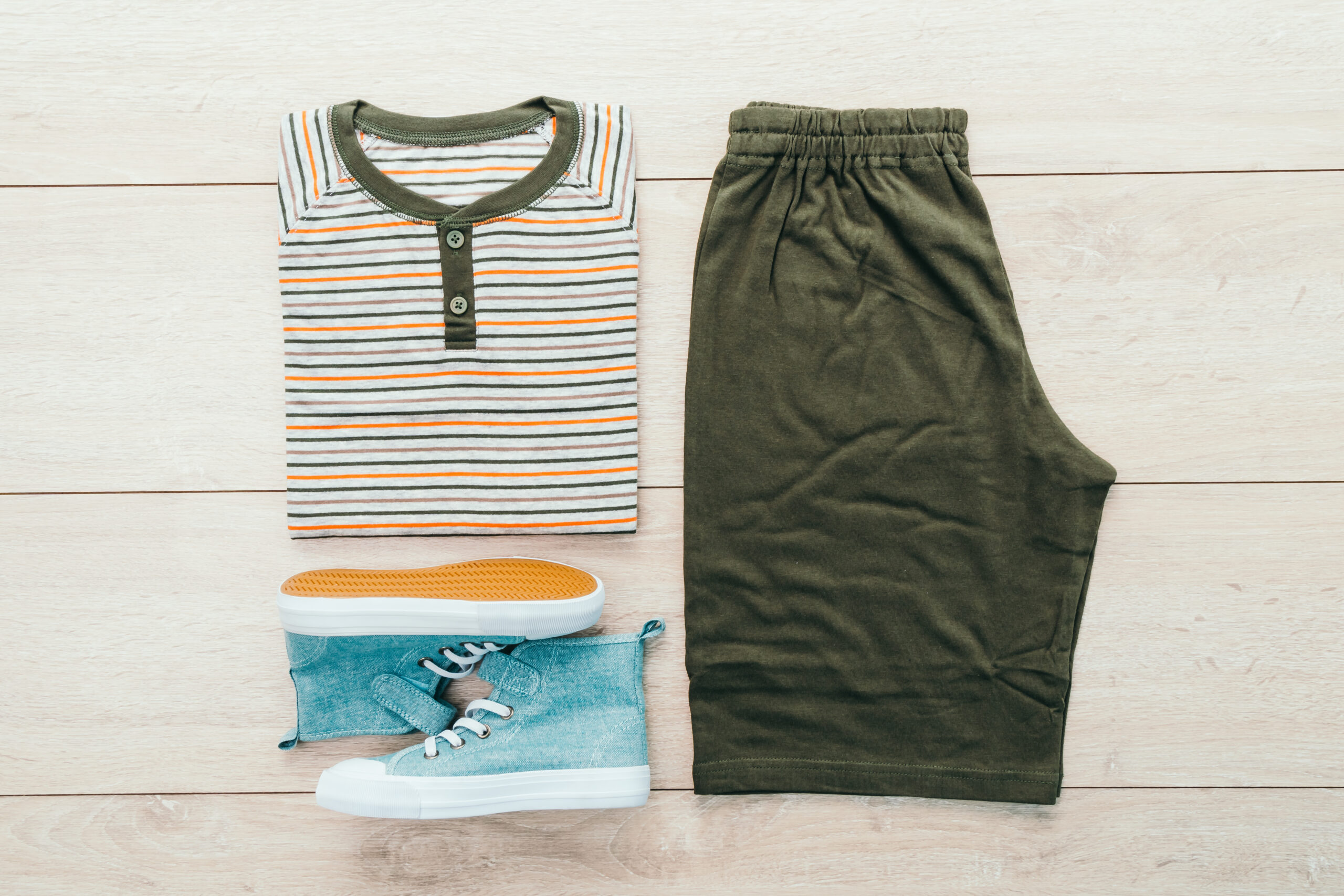 T-shirt with pants and shoes on wooden background - Vintage Filter